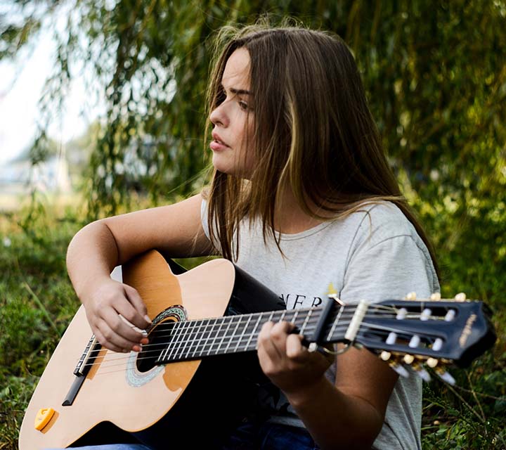 Your woman playing guitar outside
